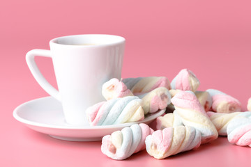 Twisted american marshmallow on pink background with coffee cup