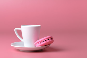 Fototapeta na wymiar One pink macaroon with cup of coffee
