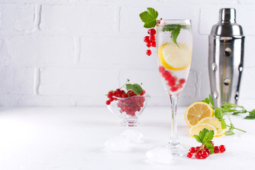 Full glass of cold refreshing  water with lemon and mint on white background