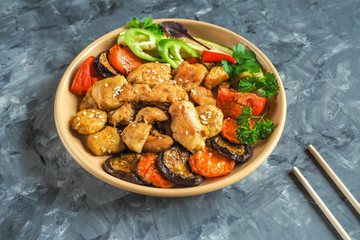 Pieces of baked meat with grilled vegetables on a plate.
