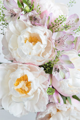 Fototapeta na wymiar Bouquet with light pink peonies and alstroemerias on a light background