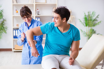 Obraz premium Doctor checking nerve reflexes with hammer