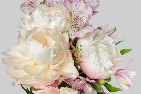 Bouquet with light pink peonies and alstroemerias on a light background