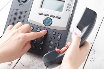 Call center or office phone concept, female finger press number on phonepad