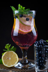 Fresh blueberry summer mojito cocktail. Blueberry lemonade or sangria on dark background