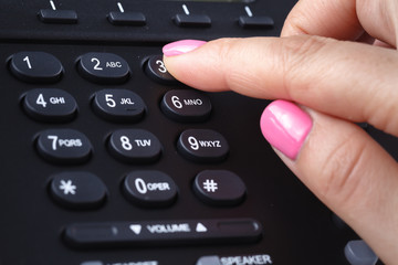 Fototapeta na wymiar Call center or office phone concept, female finger press number on phonepad