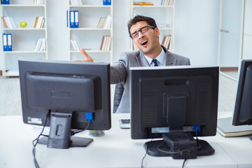 Businessman sitting in front of many screens