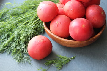 Fresh red ripe tomatoes and fresh dill greens for salad making, close-up