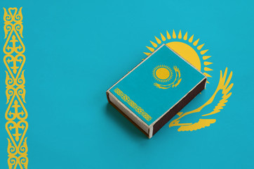 Kazakhstan flag  is pictured on a matchbox that lies on a large flag