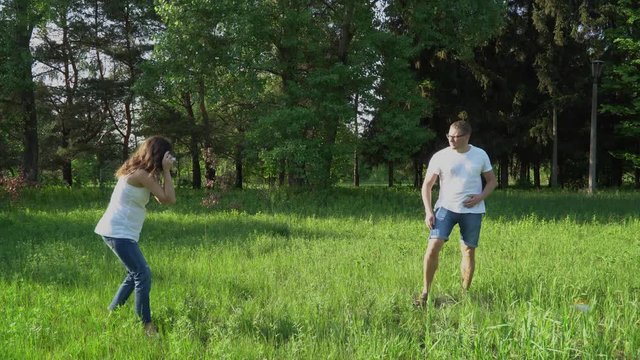 Pregnant woman photographer takes pictures outdoors.
