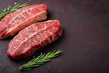 Raw fresh meat Top Blade steaks on dark background. top view with copy space