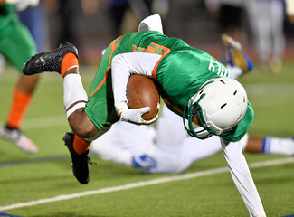 Football player running and diving for a touchdown