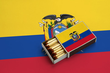 Ecuador flag  is shown in an open matchbox, which is filled with matches and lies on a large flag