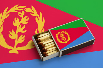 Eritrea flag  is shown in an open matchbox, which is filled with matches and lies on a large flag