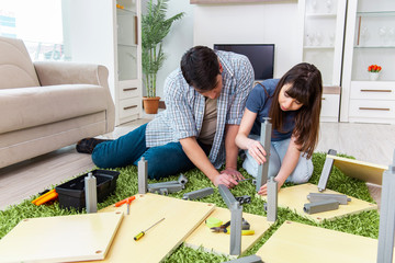 Young family assembling furniture at new house