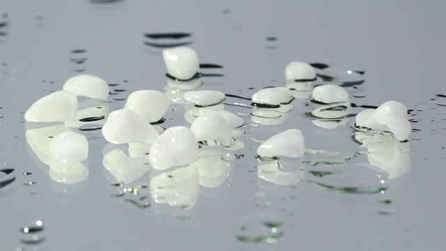 Dental veneers on isolated background water drops slowmotion