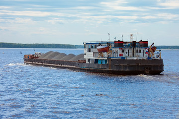 Barge with cargo sailing on the river