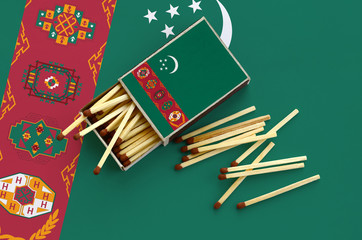 Turkmenistan flag  is shown on an open matchbox, from which several matches fall and lies on a...