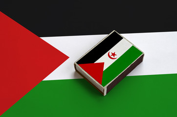 Western Sahara flag  is pictured on a matchbox that lies on a large flag