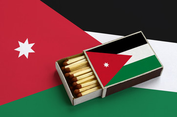 Jordan flag  is shown in an open matchbox, which is filled with matches and lies on a large flag