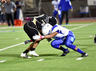 Football player making a tackle during a game