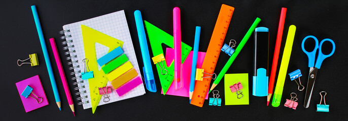 School supplies on blackboard background ready for your design. Flat lay. Top view.