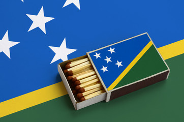 Solomon Islands flag  is shown in an open matchbox, which is filled with matches and lies on a...