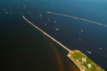 The mouth of the river Daugava. Bolderaja lighthouse and pier and breakwater. Sailboats and yachts go to sea. 