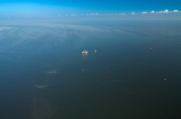 Two lonely sailboats in the middle of the sea. View from the plane.

