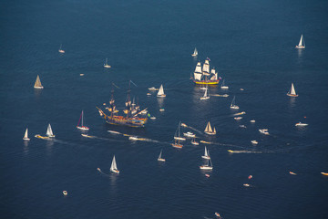A large cluster of sailboats and yachts in the mouth of the Daugava River. Sea regatta. The Varma...