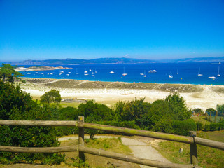 Beach of Cies Islands, in Galicia, Spain, with boats docked in front of