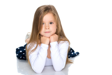 Fototapeta premium Little girl lies on the floor