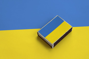 Ukraine flag  is pictured on a matchbox that lies on a large flag