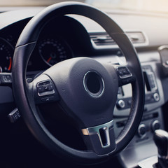 black leather steering wheel closeup.