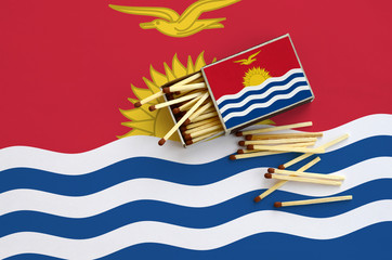 Kiribati flag  is shown on an open matchbox, from which several matches fall and lies on a large...