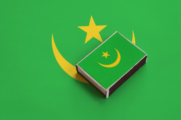 Mauritania flag  is pictured on a matchbox that lies on a large flag