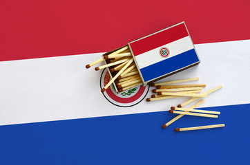 Paraguay flag  is shown on an open matchbox, from which several matches fall and lies on a large...