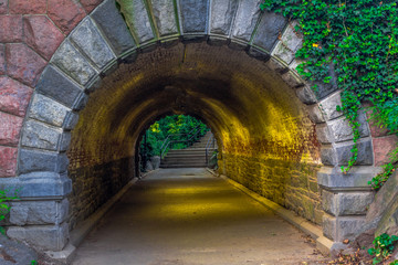 Fototapeta na wymiar Grey and Red Stone in a Short Pedestrian Tunnel