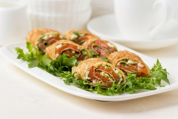 Roll pancakes with red fish and herb cream cheese.