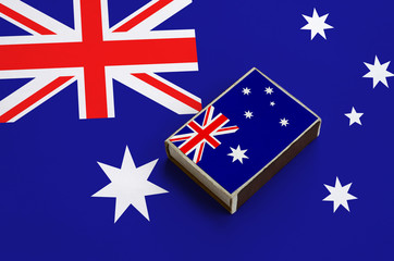 Australia flag  is pictured on a matchbox that lies on a large flag