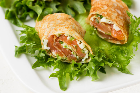 Roll pancakes with red fish and herb cream cheese.