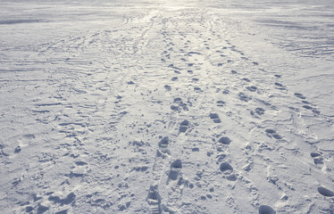 Footprints path crossing a snowy terrain, Traces on snow, background