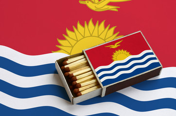 Kiribati flag  is shown in an open matchbox, which is filled with matches and lies on a large flag