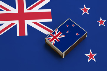 New Zealand flag  is pictured on a matchbox that lies on a large flag