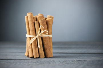Close up cinnamon sticks healthy spice on wooden background rope-bound