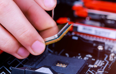 Computer technician installing CPU into motherboard. Close up.