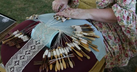 Lace making historic handmade material woman. Bobbin lace is a textile made by braiding and twisting lengths of thread by hand. Hobby for highly homemade delicate clothing.