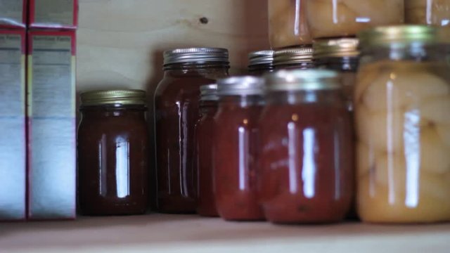Stacking freshly canned or bottled food on the pantry self for food storage.