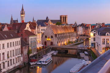 Fototapeta na wymiar Aerial view of picturesque medieval buildings on the quay Graslei and towers of Old Town during morning blue hour, Ghent, Belgium