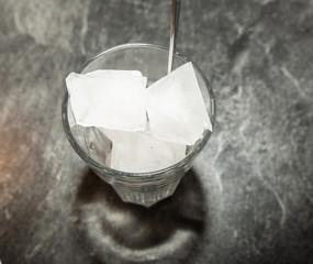 Glass filled with ice cubes and a long spoon.